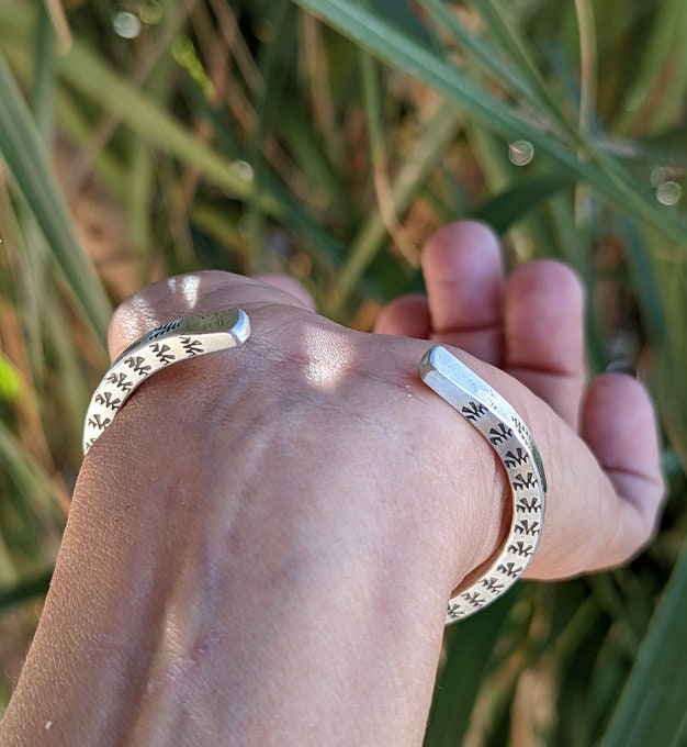 Square sterling silver wire cuff bracelet with Thunderbird patterning on 3 sides