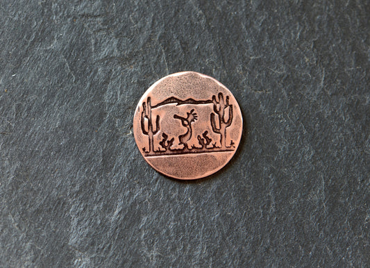 Golf ball marker with saguaro cacti and Kokopelli on copper