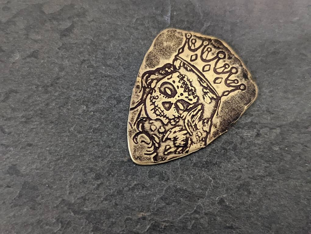 Bronze shield shaped guitar pick with Day of the Dead Theme