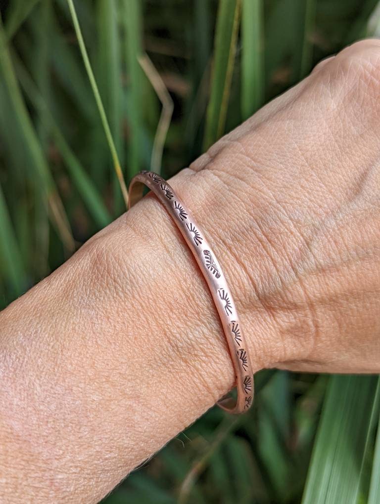 Copper bracelet stamped with sun and Thunderbird