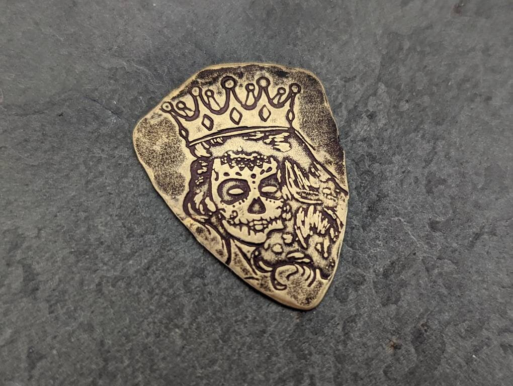 Bronze shield shaped guitar pick with Day of the Dead Theme