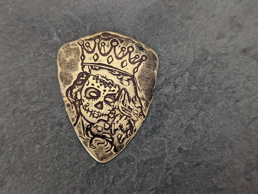 Bronze shield shaped guitar pick with Day of the Dead Theme