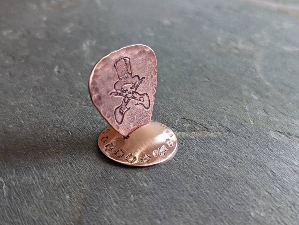 Copper guitar pick with skull and guitars theme