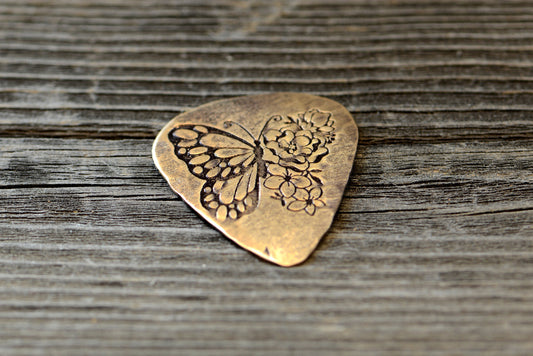 Bronze guitar pick with butterfly and flowers