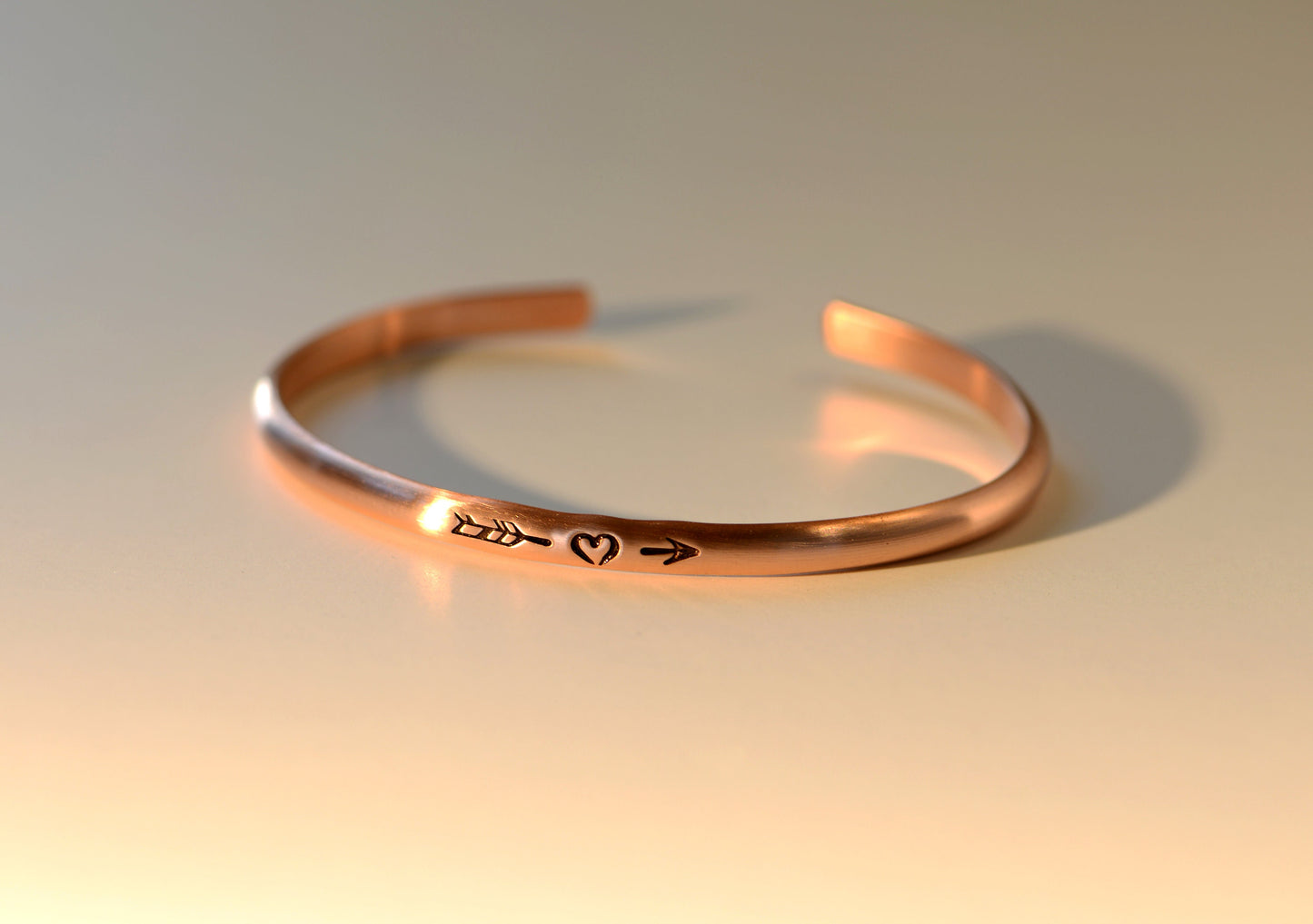Copper bracelet with arrow and a heart in dainty styling for stacking