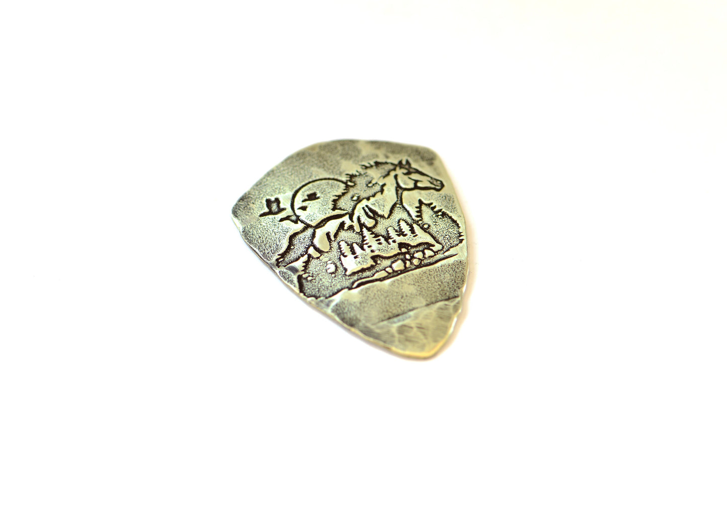 Shield shaped brass guitar pick with horse and forest