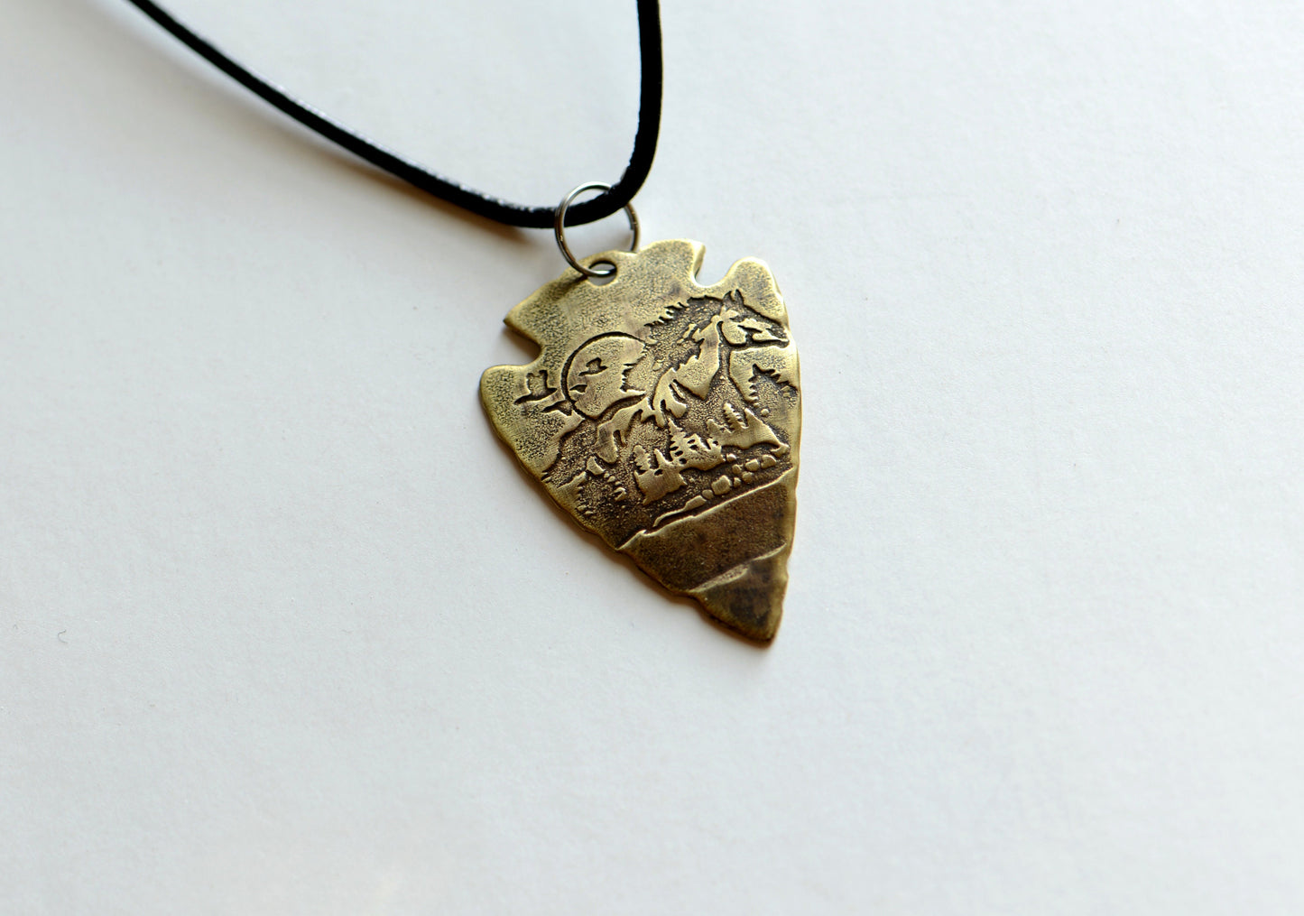 Bronze arrowhead necklace with horses and mountains