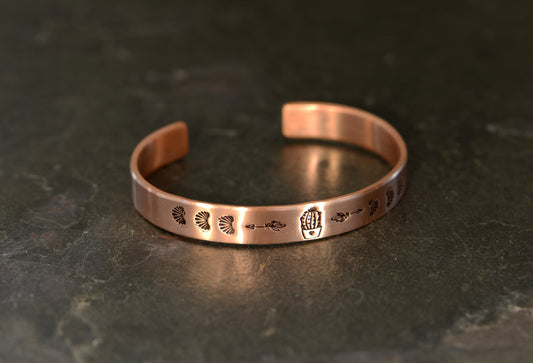 Guitar pick copper bracelet with cactus in a pot along with arrows