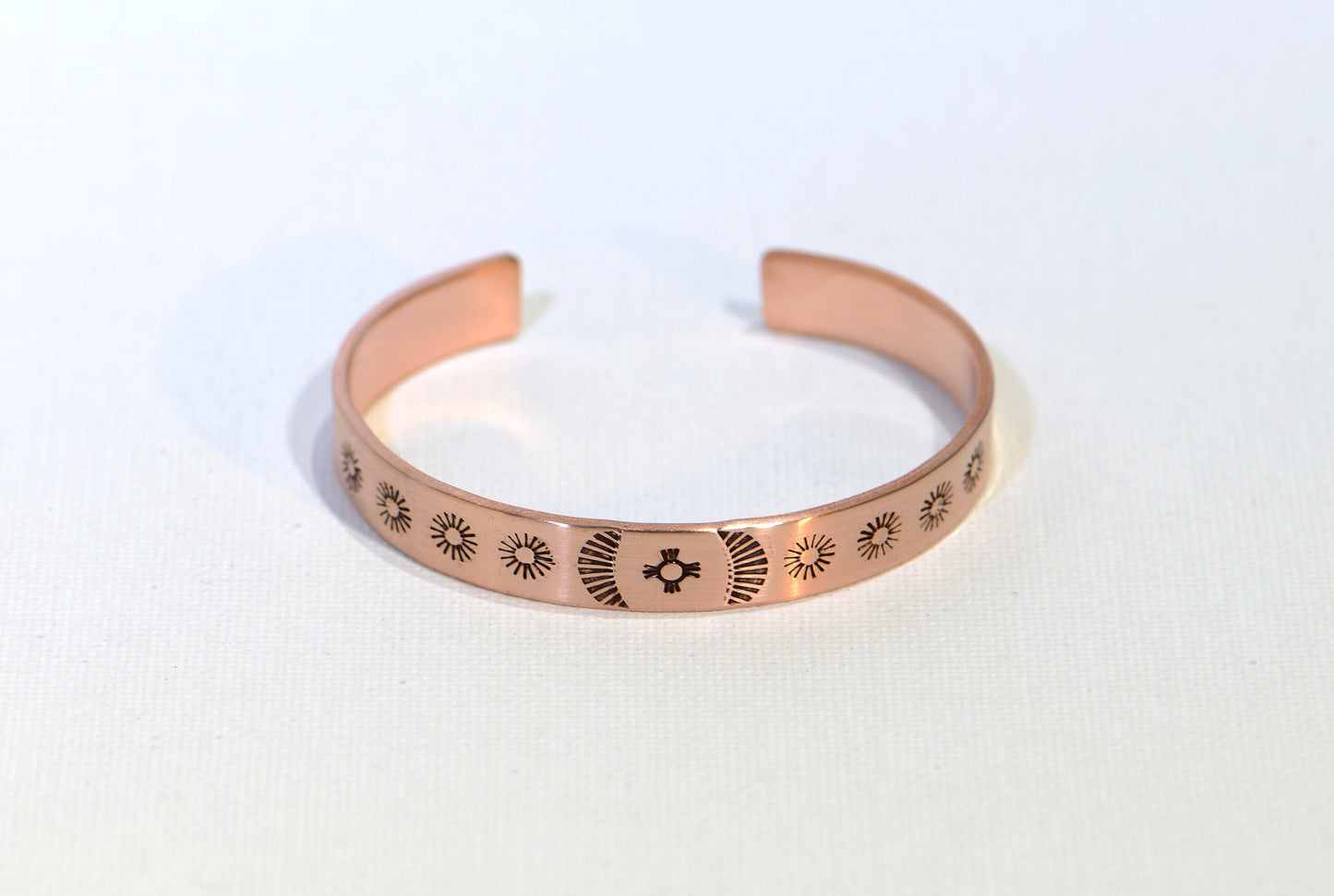 Cuff bracelet hand stamped with zia symbol and southwestern patterns in copper