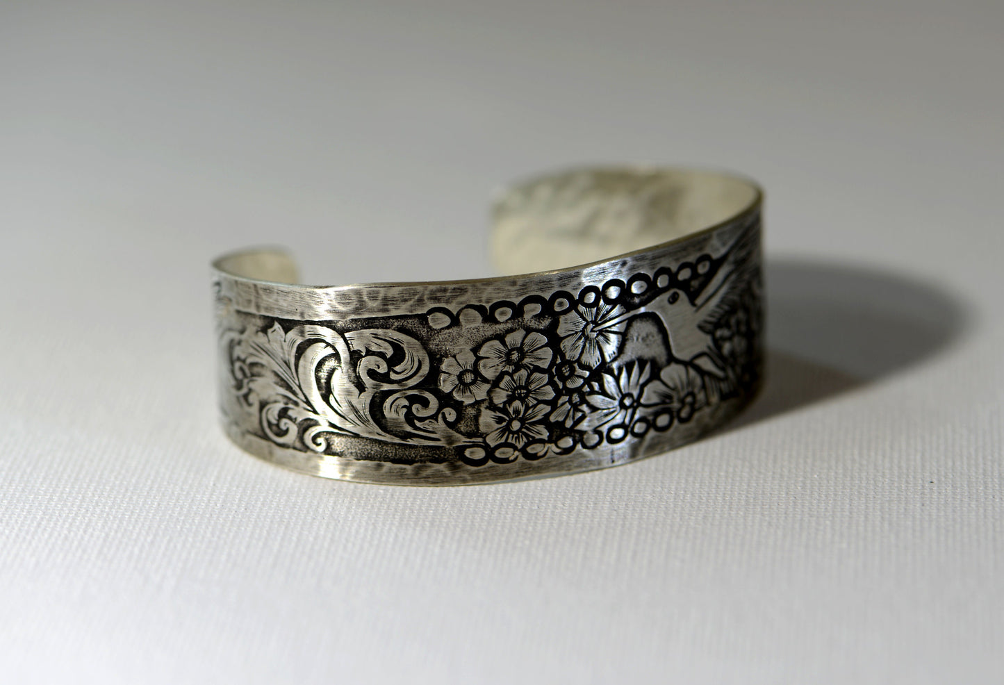 Hummingbird and flowers on a sterling silver cuff bracelet