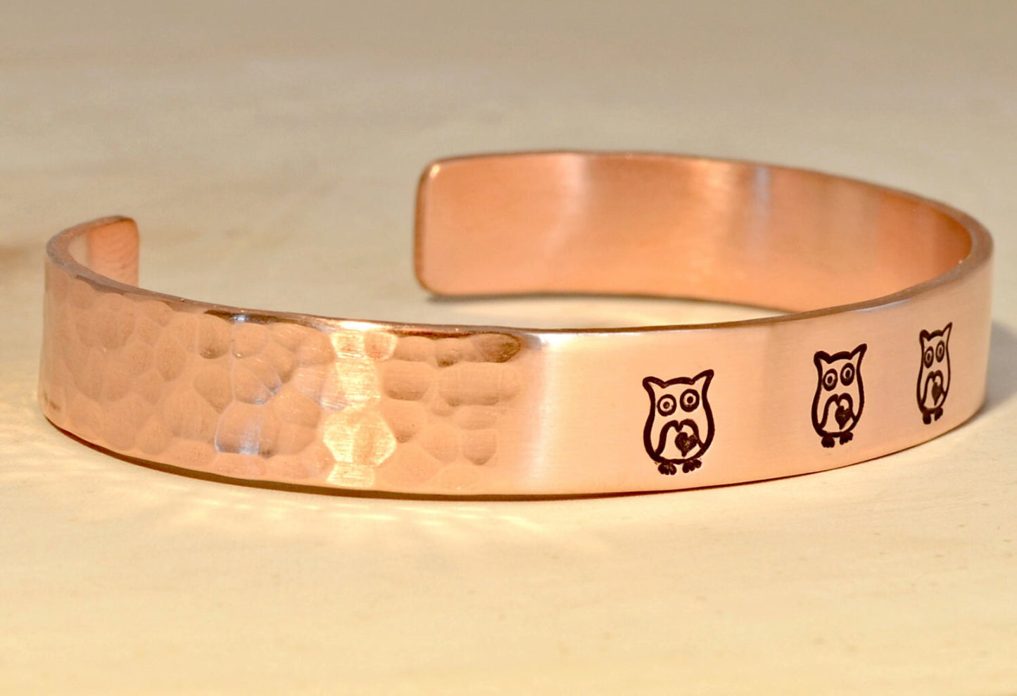 Copper cuff bracelet with hammered texture and owls