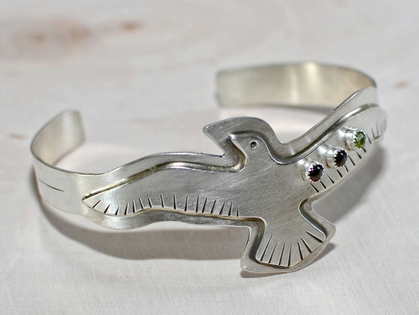 Sterling silver bird bracelet with red Garnet and green Peridots