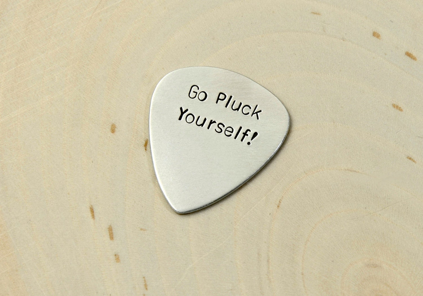 Silver guitar pick with Go Pluck Yourself