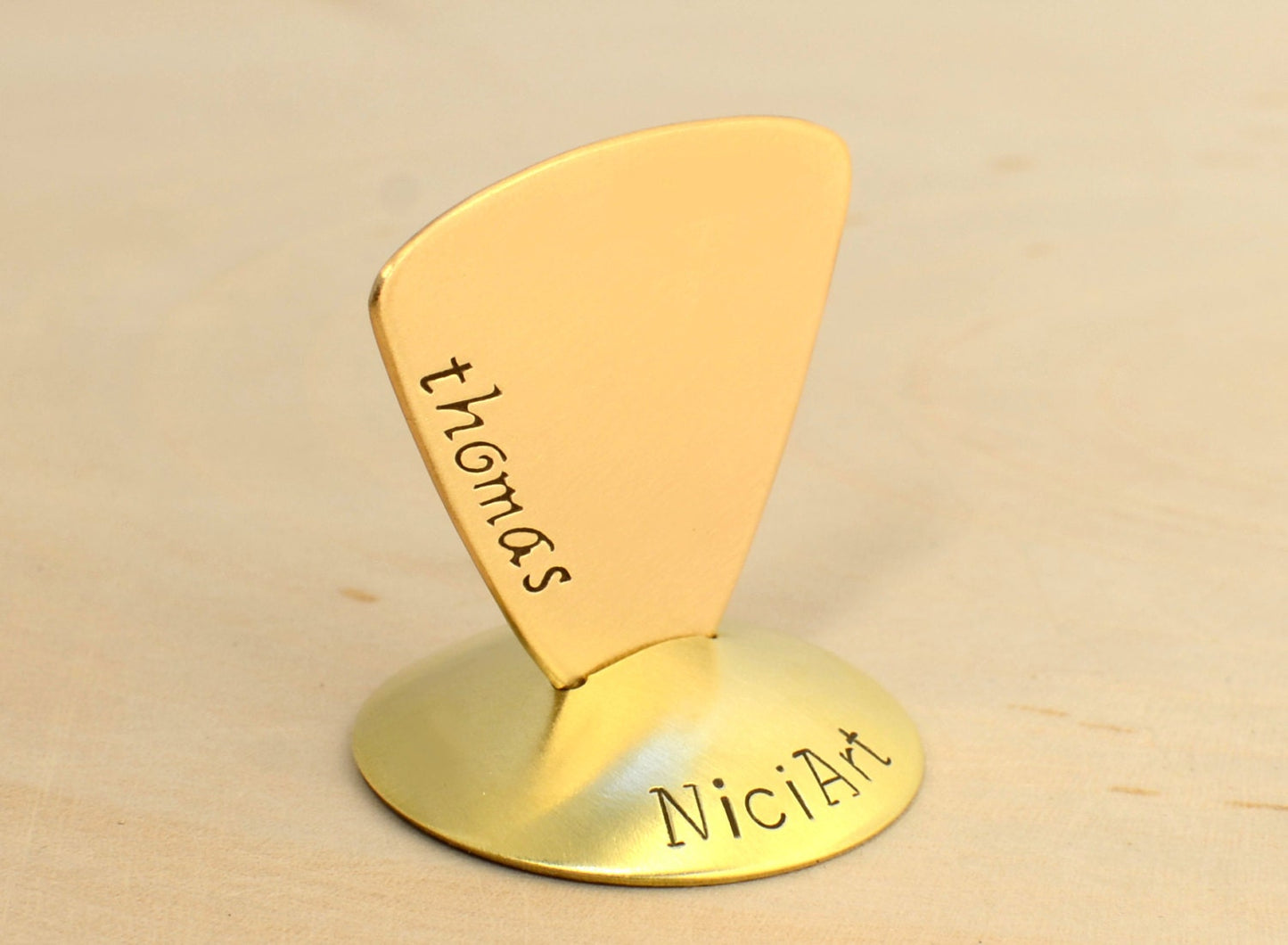 Brass triangular guitar pick with custom names and engraving