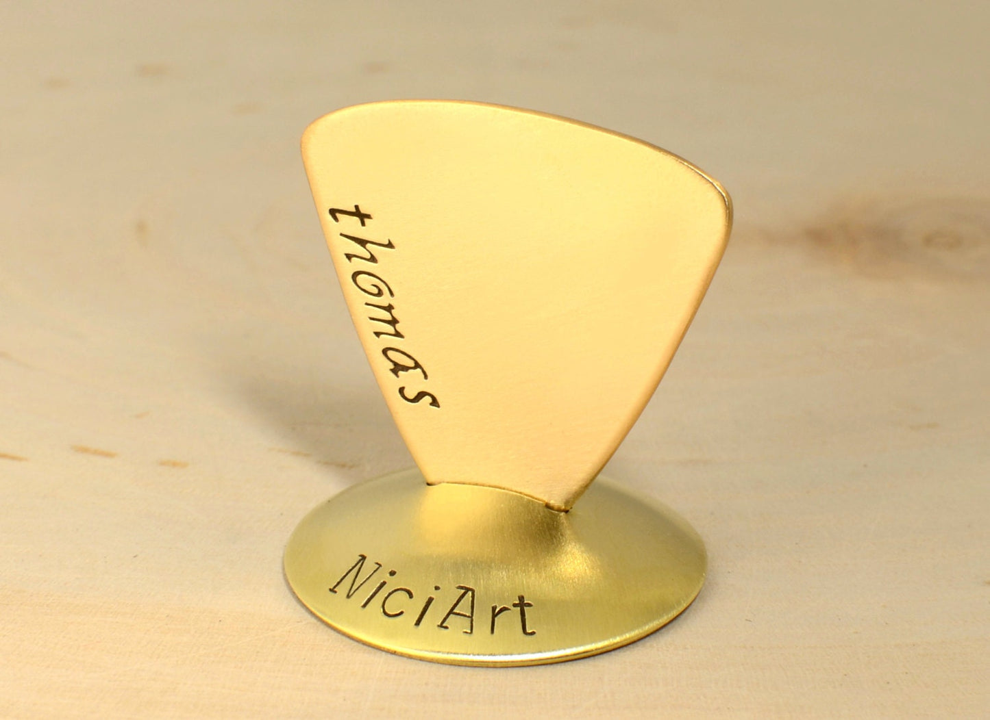 Brass triangular guitar pick with custom names and engraving