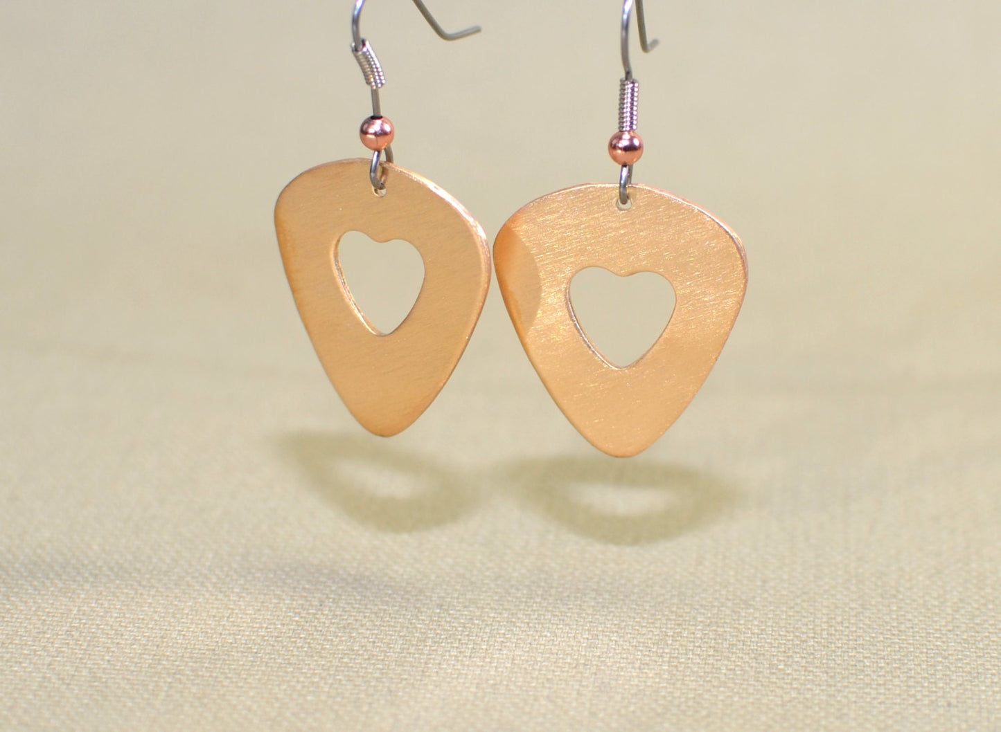 Bronze guitar pick earrings with cutout hearts