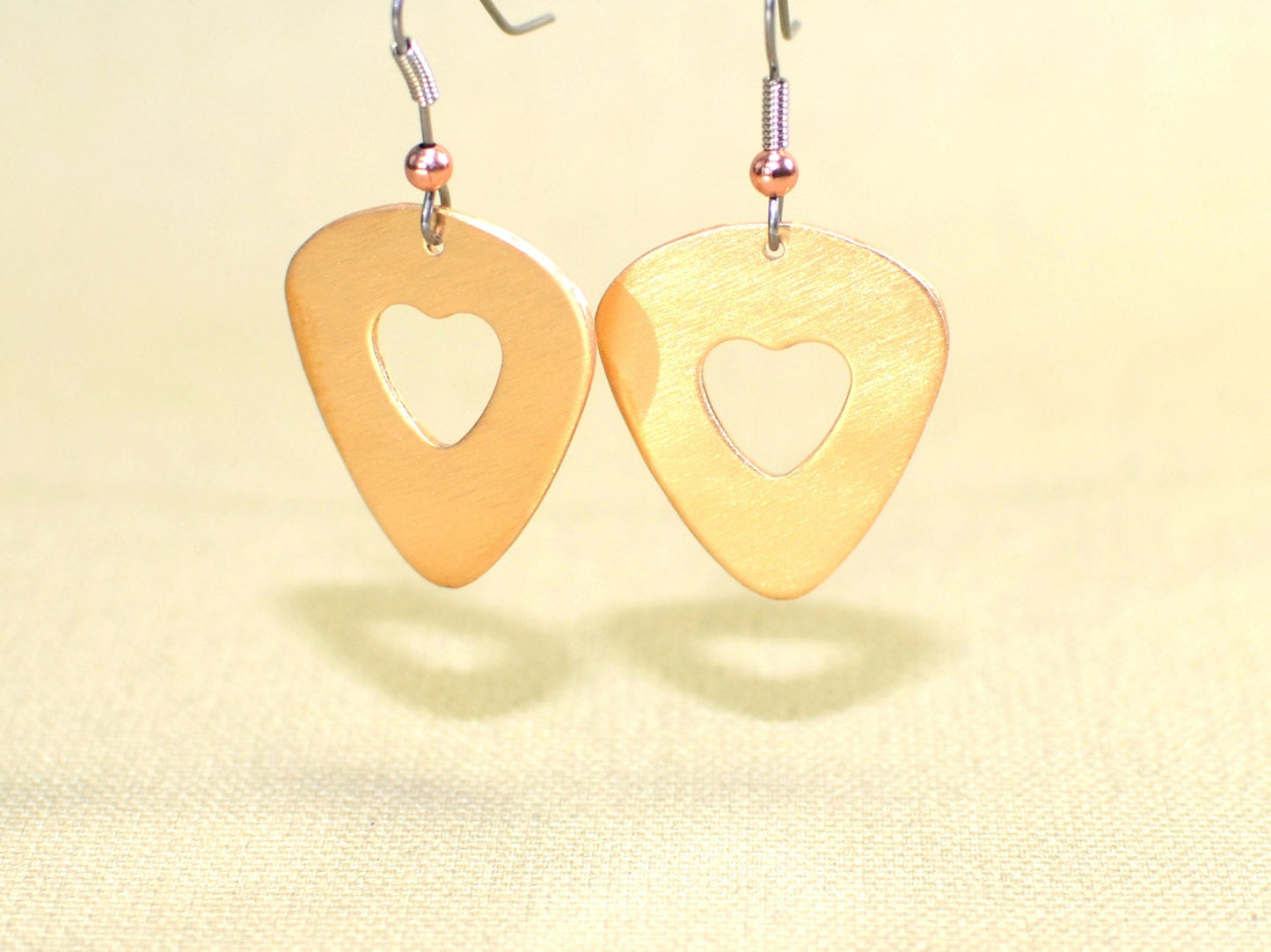 Bronze guitar pick earrings with cutout hearts
